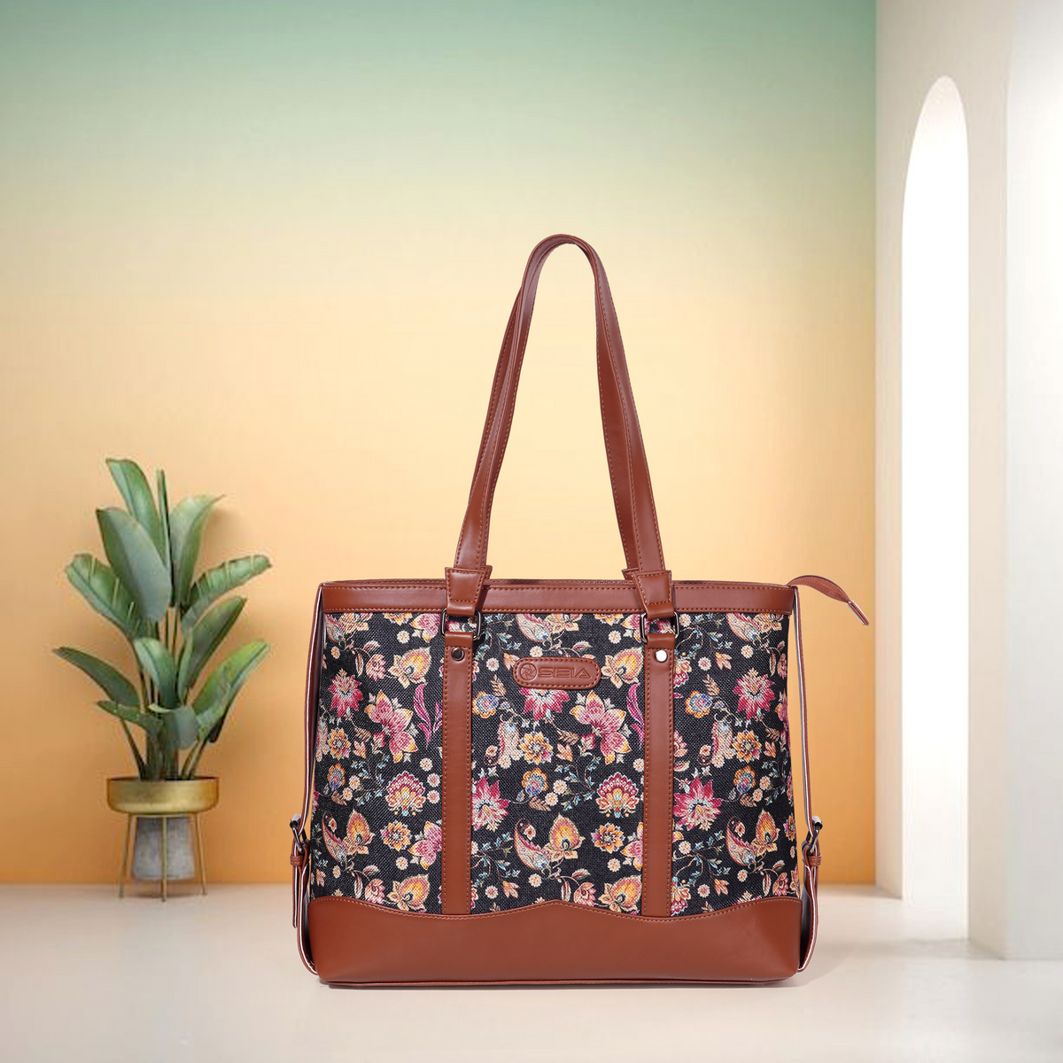 Floral-patterned womens office bag with brown leather straps on a gradient background